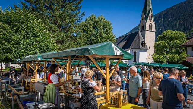 Marktstände mit grünen Dächern vor der Pfarrkirche Mayrhofen